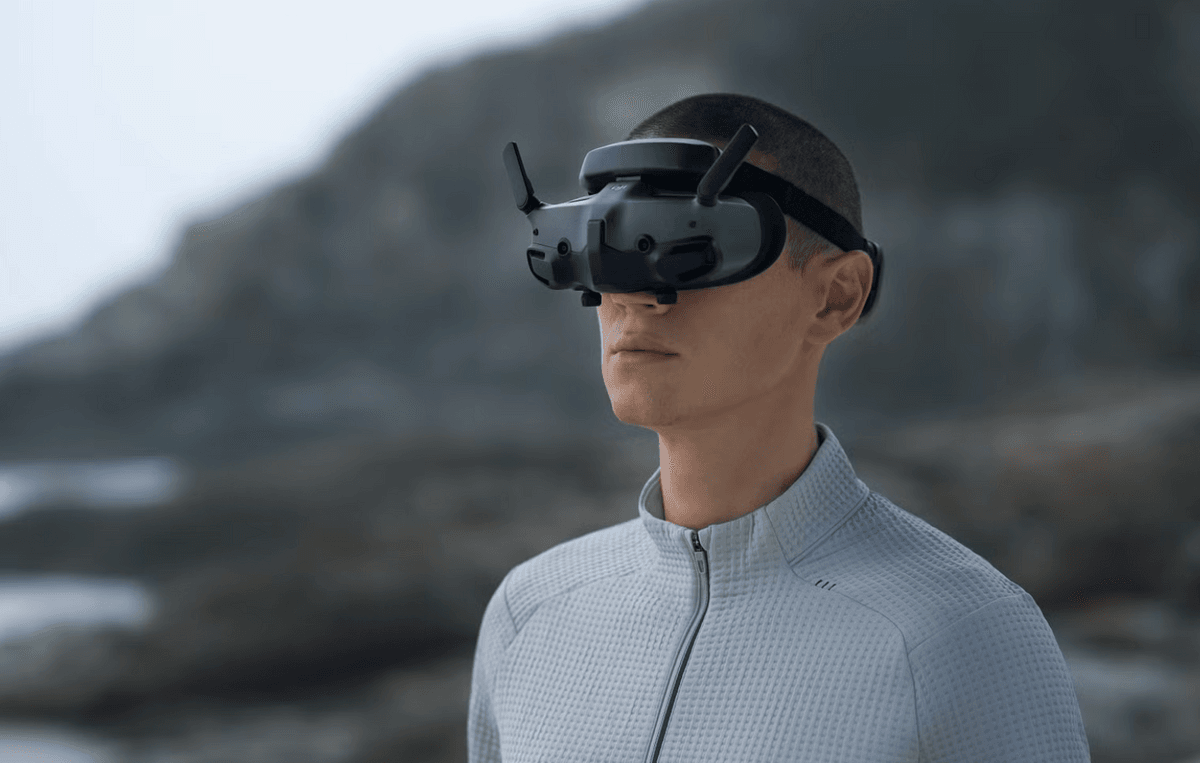 Pilote portant des lunettes FPV devant un paysage montagneux